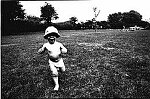 Photography of small boy running in park black and white